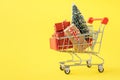 Shopping cart full of various gift boxes and a Christmas tree Royalty Free Stock Photo
