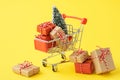 Shopping cart full of various gift boxes and a Christmas tree Royalty Free Stock Photo