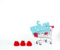 Shopping cart with Happy New Year greeting plate in Russian with three red woolen harts on white background Royalty Free Stock Photo