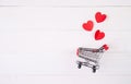 Shopping cart and heart shape paper on wooden table sale concept in festive valentine day February 14 supermarket and store