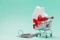 Shopping cart with house decorated bow ribbon, dollars money and bunch of keys. Buying new home, gift or sale real estate. Royalty Free Stock Photo