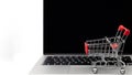 Shopping cart on a laptop keyboard isolated on white background, E-commerce, Shopping cart on laptop, Conceptual image, Ideas abou