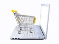 Shopping cart and laptop side view isolated on white. Electronic commerce concept Royalty Free Stock Photo