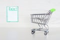 Shopping cart with light green handler. Market stroller on a light grey background. Copy space with title Sale on the