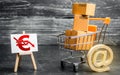 Shopping cart loaded with boxes, email symbol and euro red down arrow. Reduced online sales over Internet. Fall purchasing power Royalty Free Stock Photo