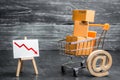 Shopping cart loaded with boxes, email symbol and red down arrow. Reduced online sales over the Internet. Fall in purchasing power Royalty Free Stock Photo