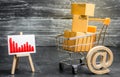 Shopping cart loaded with boxes, email symbol and red negative trend chart. Reduced online sales over the Internet. Royalty Free Stock Photo