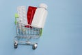 Shopping cart loaded with pills on blue background. The concept of medicine and the sale and delivery of drugs. Copy space Royalty Free Stock Photo