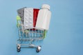 Shopping cart loaded with pills on blue background. The concept of medicine and the sale and delivery of drugs. Copy space Royalty Free Stock Photo