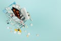 Shopping cart loaded with pills on a blue background. The concept of medicine and the sale of drugs. Copy space Royalty Free Stock Photo