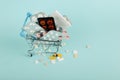 Shopping cart loaded with pills on a blue background. The concept of medicine and the sale of drugs. Copy space Royalty Free Stock Photo