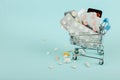 Shopping cart loaded with pills on a blue background. The concept of medicine and the sale of drugs. Copy space Royalty Free Stock Photo