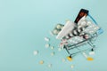 Shopping cart loaded with pills on a blue background. The concept of medicine and the sale of drugs. Copy space Royalty Free Stock Photo