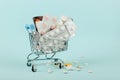 Shopping cart loaded with pills on a blue background. The concept of medicine and the sale of drugs. Copy space Royalty Free Stock Photo