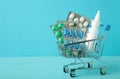 Shopping cart loaded with pills on blue background. The concept of medicine and the sale of drugs. Copy space Royalty Free Stock Photo