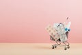 Shopping cart loaded with pills on a pink yellow background. The concept of medicine and the sale of drugs. Copy space