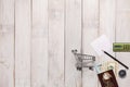 Shopping cart with money banknote and pencil,white paper,compass on white wood,concept of financial planning.