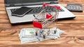 Shopping cart with money and credit card, laptop and smartphone on the table. Online shopping and Ecommerce