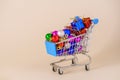 Shopping cart with multicolored christmas balls for decorating christmas tree Royalty Free Stock Photo