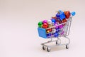 Shopping cart with multicolored christmas balls for decorating christmas tree Royalty Free Stock Photo