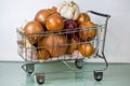 Shopping cart with onions and garlic white background Royalty Free Stock Photo