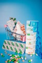 Shopping cart and pills in blisters and plastic container for medicines. Concept of buying medicine online, delivery of Royalty Free Stock Photo