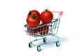 Shopping cart with red ripe tomatoes on white background Royalty Free Stock Photo