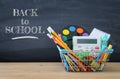 Shopping cart with school supply in front of blackboard. Back to school concept. Royalty Free Stock Photo