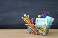 Shopping cart with school supply in front of blackboard. Back to school concept. Royalty Free Stock Photo