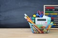 Shopping cart with school supply in front of blackboard. Back to school concept. Royalty Free Stock Photo