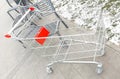 Shopping cart on the street in winter. Snow on the grass, color photo