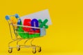 Shopping cart or supermarket trolley with fifty percent sign and full of colorful numbers on yellow background Royalty Free Stock Photo