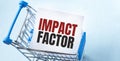 Shopping cart and text impact factor on white paper note list. Shopping list concept on blue background Royalty Free Stock Photo
