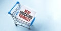 Shopping cart and text KEEP EDUCATING YOURSELF on white paper note list. Shopping list concept on blue background Royalty Free Stock Photo
