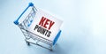 Shopping cart and text key points on white paper note list. Shopping list concept on blue background