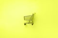 Shopping cart on trendy neon yellow color background. Minimalism style. Creative design. Shop trolley at supermarket. Sale,