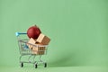 Xmas shopping, cart with two red christmas balls on a green background Royalty Free Stock Photo
