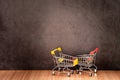 Shopping cart on wooden table with old gray concrete wall for background. Royalty Free Stock Photo