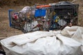 Shopping carts filled with trash and recylables are adjacent to debris and a homeless camp at 8100 Haskell Av