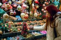 Shopping for Christmas Holidays, young woman at market display window choosing tree decorations