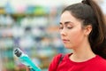 Shopping. Close up portrait of young pretty woman reading information on a bottle of cosmetics. The concept of buying cosmetic Royalty Free Stock Photo