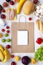 Shopping concept. Set of various groceries with paper bag and blank notepad on white wooden table, top view. Cooking food backgrou Royalty Free Stock Photo