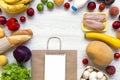 Shopping concept. Set of various groceries with paper bag and notepad on white wooden table. Cooking food background. Flat lay of Royalty Free Stock Photo