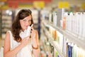 Shopping cosmetics - woman smelling shampoo Royalty Free Stock Photo