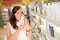 Shopping cosmetics - woman smelling shampoo Royalty Free Stock Photo