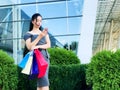 Shopping day. Woman holding colored bags near her shooping mall in black friday holiday Royalty Free Stock Photo