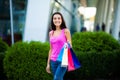 Shopping day. Woman holding colored bags near her shooping mall in black friday holiday. Royalty Free Stock Photo