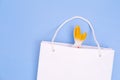 Shopping for Easter. White paper shopping bag with white bunny on blue background. Concept Easter gifts, surprise. Royalty Free Stock Photo