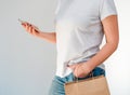 Shopping ecological style concept. A woman in jeans and a light cotton T-shirt with a phone and eco paper bags in her hands Royalty Free Stock Photo