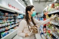 Shopping during an epidemic.Buyer wearing a protective mask.Nonperishable smart purchased household pantry groceries.Pandemic